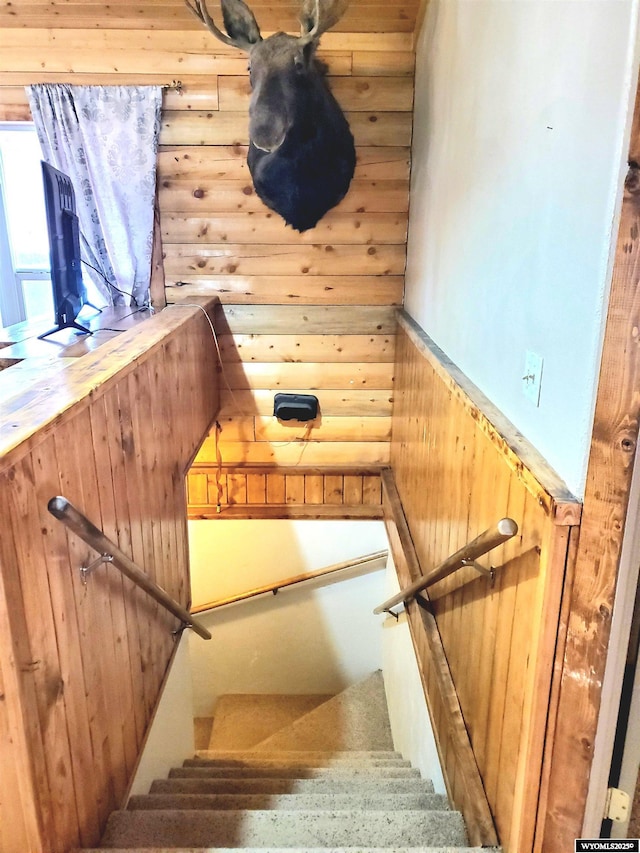 stairs featuring rustic walls and wood walls