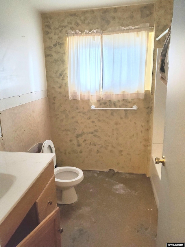 bathroom featuring vanity, a wainscoted wall, and toilet