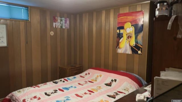 bedroom featuring wood walls