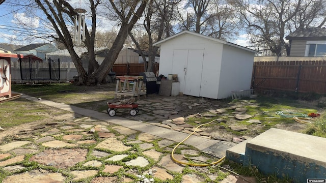 view of shed featuring a fenced backyard and a trampoline