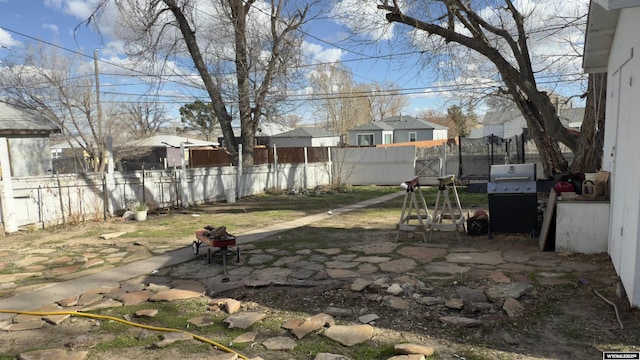 view of yard with a patio, a residential view, fence, and a fire pit