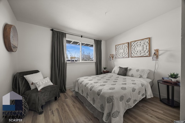 bedroom featuring baseboards, vaulted ceiling, and wood finished floors