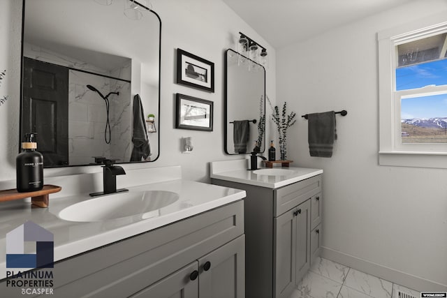 full bathroom with baseboards, a marble finish shower, a sink, and marble finish floor