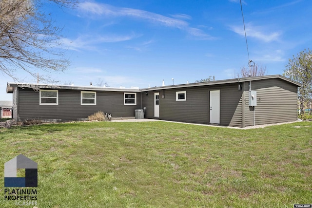 rear view of property with a lawn, a patio, and central air condition unit