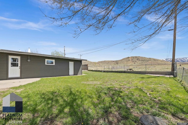 view of yard featuring a fenced backyard, a mountain view, and a patio area