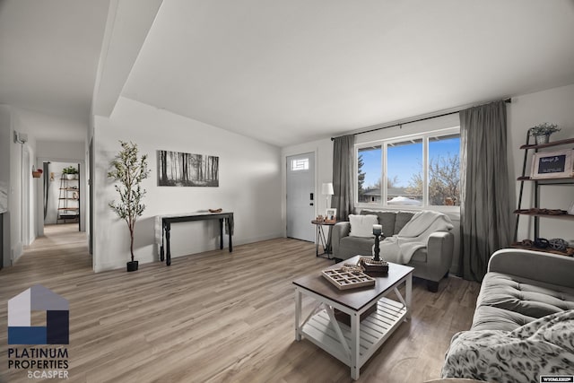 living area with light wood-style floors, baseboards, lofted ceiling, and a healthy amount of sunlight