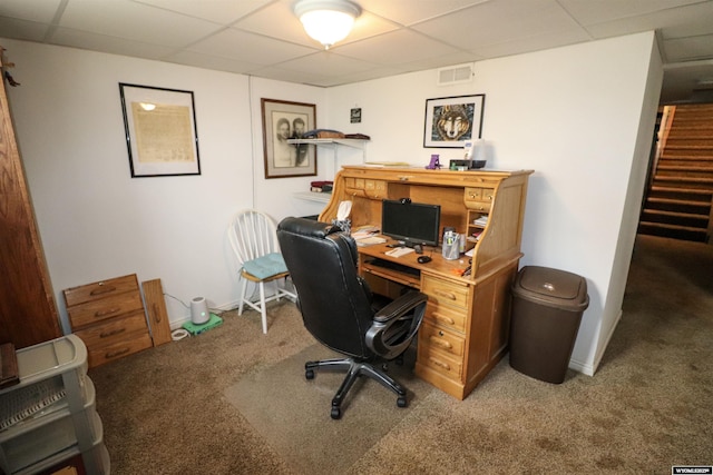 carpeted office with visible vents, baseboards, and a drop ceiling