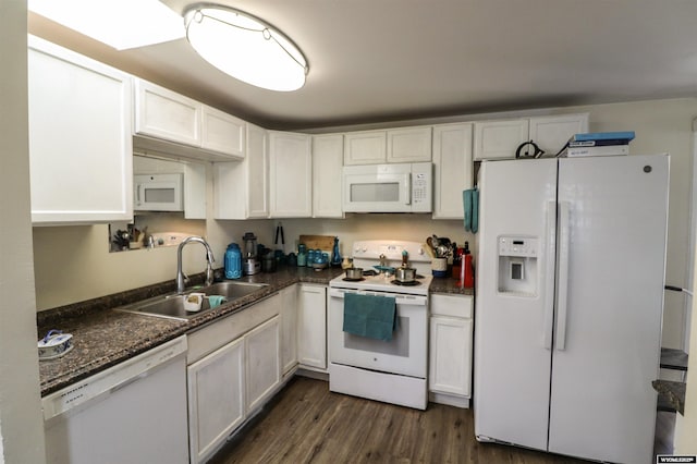 kitchen with white cabinets, dark countertops, a sink, white appliances, and dark wood-type flooring