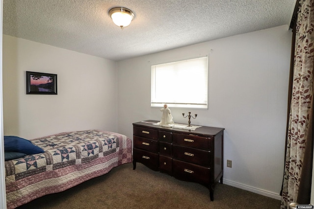bedroom with dark carpet and a textured ceiling