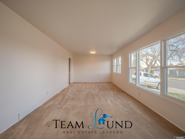 spare room featuring carpet floors and visible vents