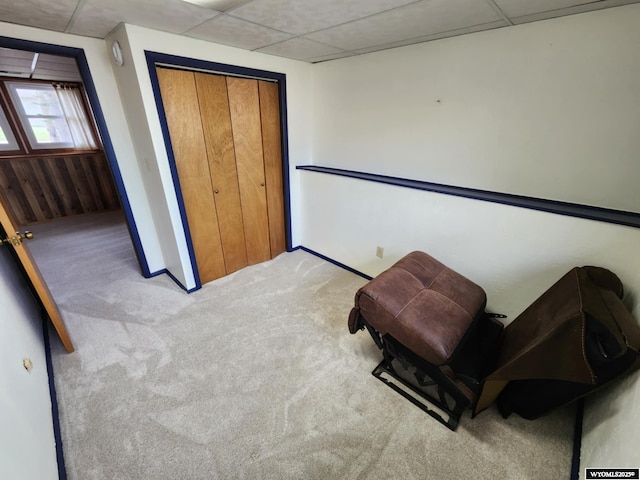 sitting room featuring baseboards, carpet, and a paneled ceiling