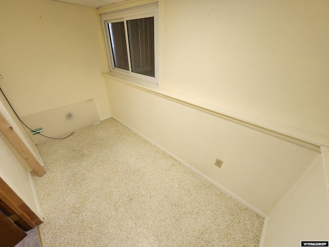 unfurnished room featuring carpet floors and baseboards