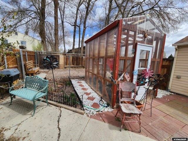 view of patio with an outdoor structure, a fenced backyard, and an exterior structure