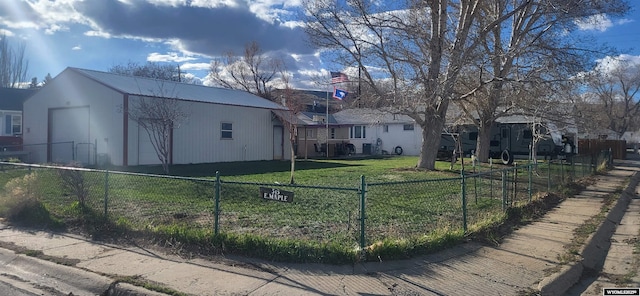 exterior space featuring fence, a residential view, an outbuilding, a lawn, and metal roof