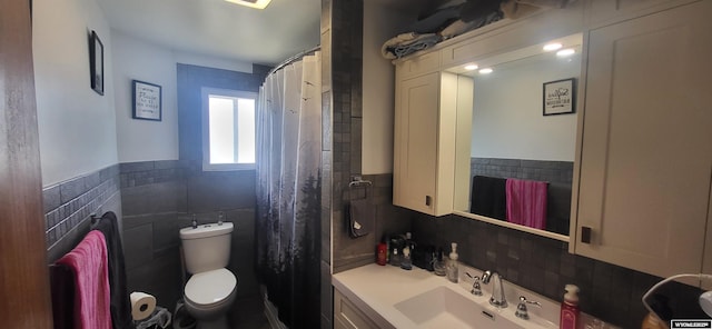 full bath with wainscoting, tile walls, vanity, and toilet