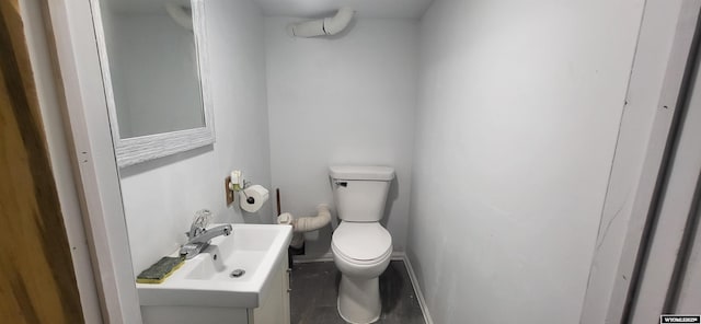 half bath with vanity, baseboards, and toilet