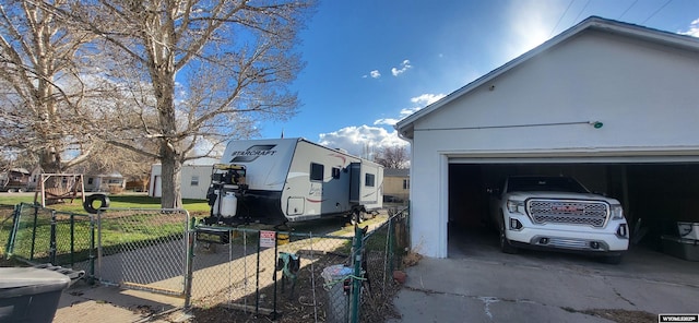 view of home's exterior with stucco siding, a gate, a garage, and fence