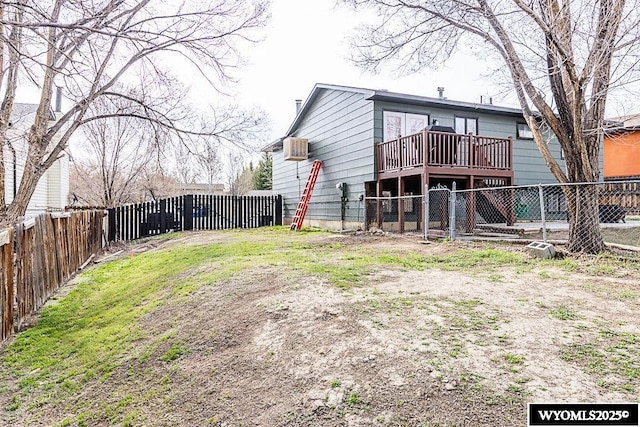 back of house with a fenced backyard and a wooden deck