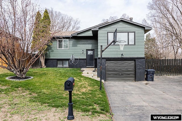 view of front of house featuring fence, an attached garage, a front lawn, brick siding, and driveway