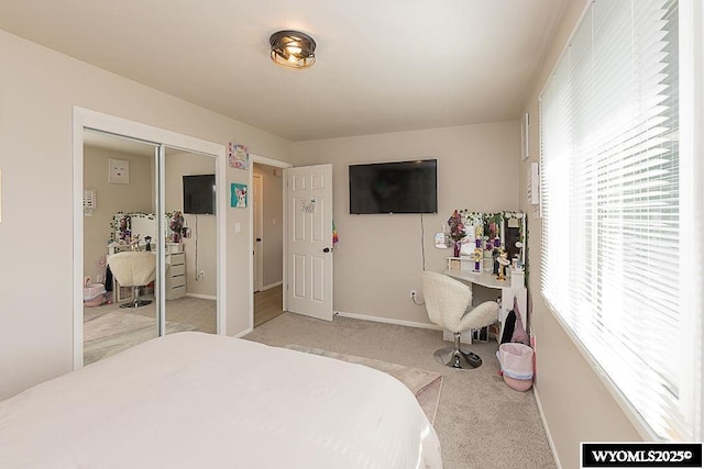 carpeted bedroom featuring baseboards and a closet