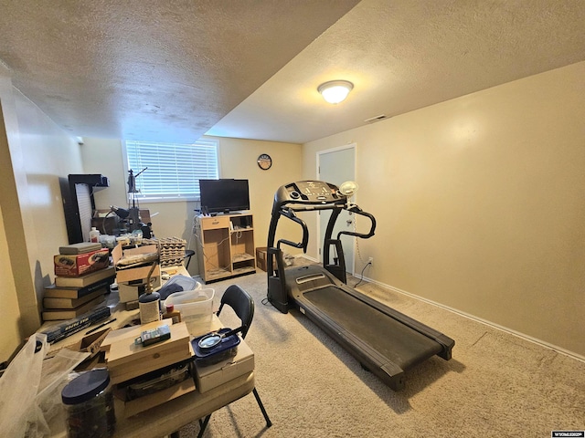 exercise area with carpet floors, a textured ceiling, visible vents, and baseboards