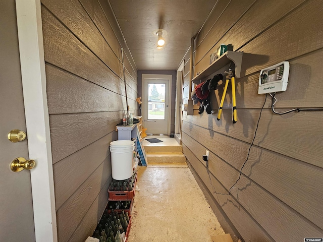interior space with wood walls and unfinished concrete flooring