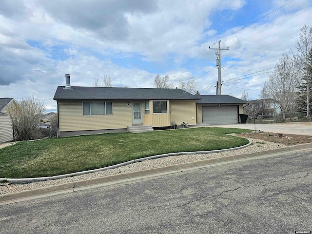 ranch-style house featuring a garage, entry steps, a front yard, and concrete driveway