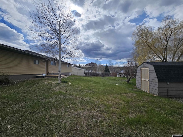 view of yard featuring an outdoor structure, a shed, and fence