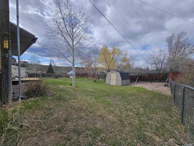 view of yard featuring an outdoor structure, a fenced backyard, and a shed