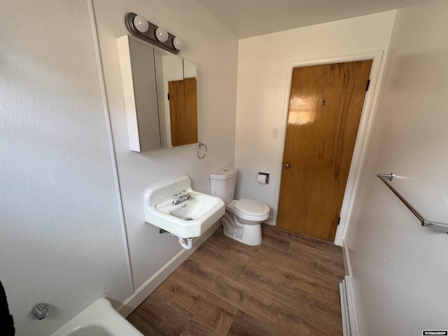 bathroom with a sink, toilet, and wood finished floors