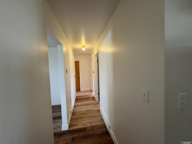 hallway featuring baseboards and wood finished floors