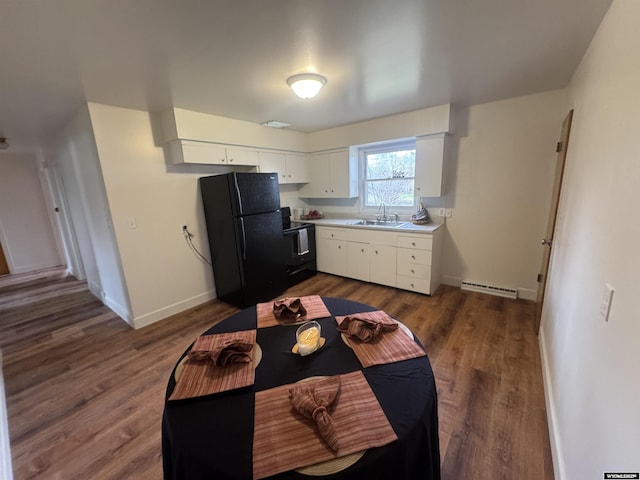 kitchen featuring light countertops, baseboards, white cabinets, a sink, and black appliances