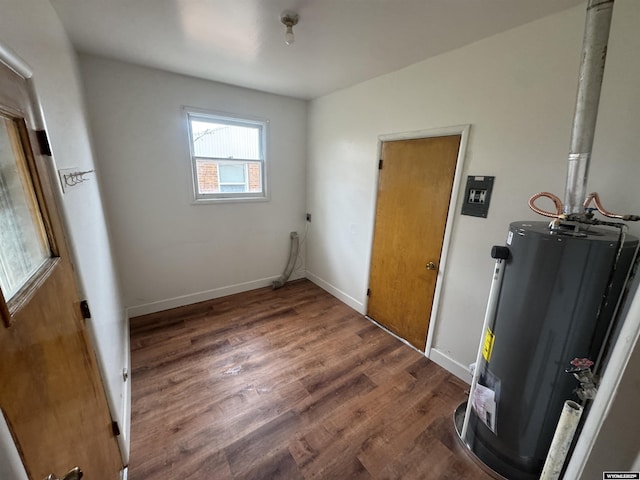 interior space featuring baseboards, water heater, and wood finished floors