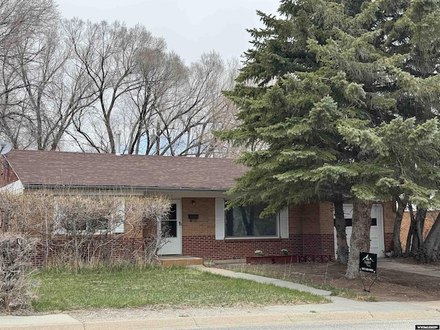 ranch-style house with brick siding and roof with shingles