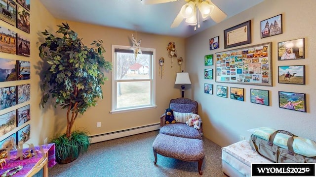 sitting room with carpet floors, ceiling fan, and a baseboard heating unit