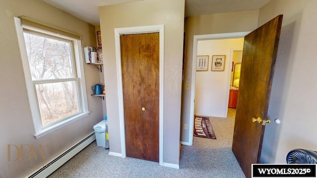 carpeted bedroom with baseboards, baseboard heating, and a closet