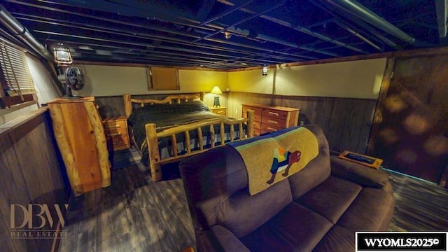 bedroom featuring wood walls and wood finished floors