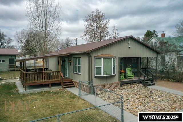 view of front facade with a deck and fence