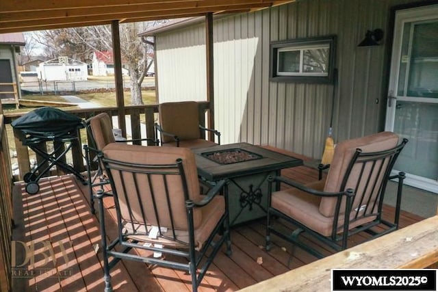 wooden deck featuring a fire pit and area for grilling