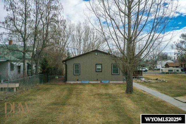 view of side of property featuring a yard and fence