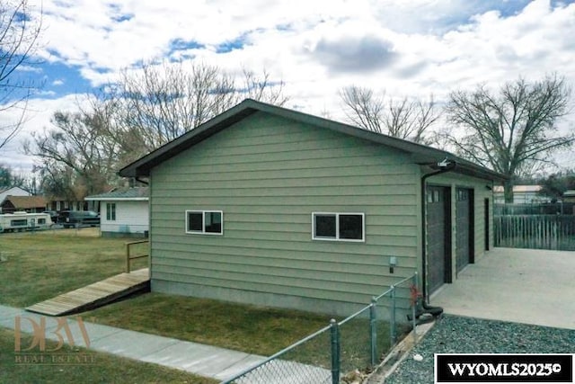 view of home's exterior with fence and a yard
