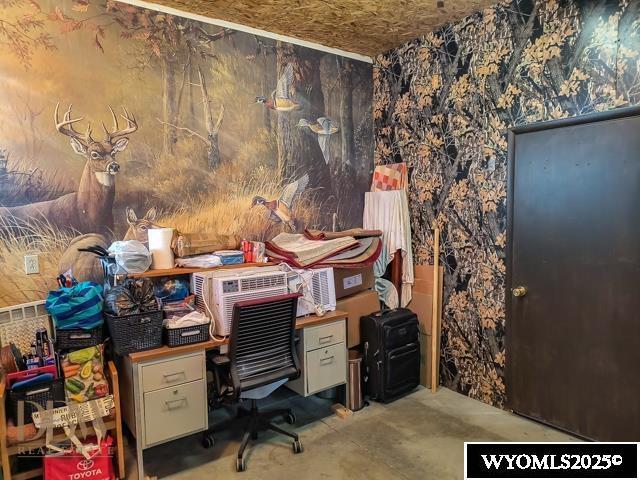 office with concrete floors and wallpapered walls