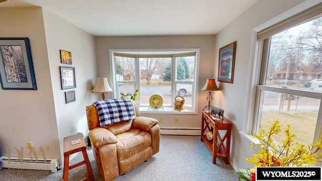 living area with carpet floors, baseboards, and a baseboard heating unit