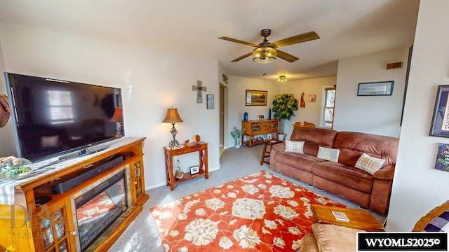 living area with carpet floors, ceiling fan, and baseboards