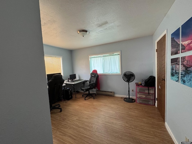 104 Brinton Rd, Lyman, WY 82937 - home office featuring a textured ceiling, wood finished floors, a baseboard heating unit, and baseboards