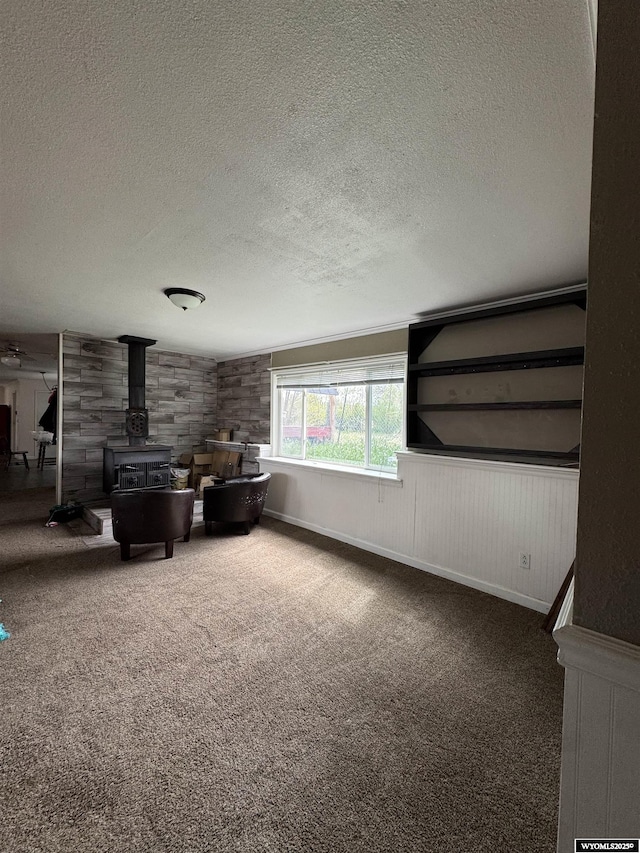 104 Brinton Rd, Lyman, WY 82937 - carpeted living room featuring a wood stove and a textured ceiling
