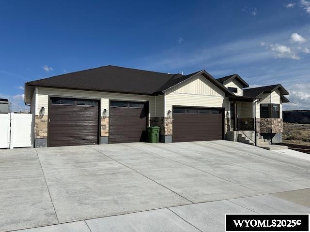 109 Chardonnay, Rock Springs, WY 82901 - view of front of house with an attached garage, stone siding, and concrete driveway