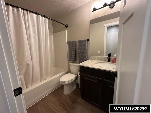 109 Chardonnay, Rock Springs, WY 82901 - full bathroom with a textured ceiling, wood finished floors, vanity, toilet, and shower / bath combo with shower curtain