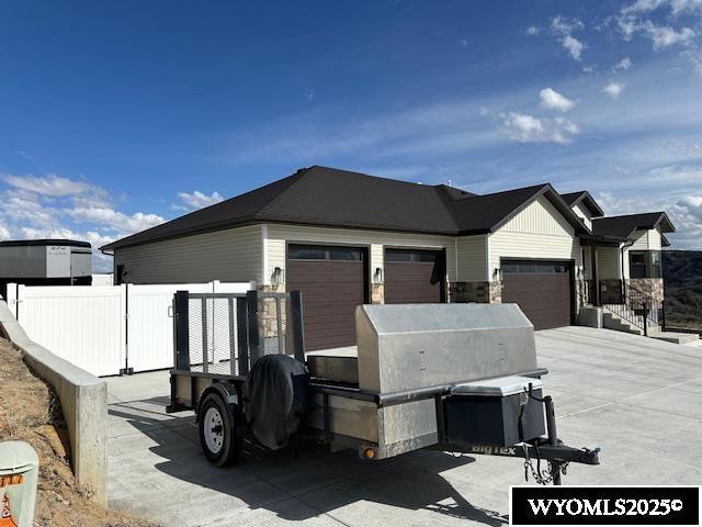 109 Chardonnay, Rock Springs, WY 82901 - view of home's exterior with fence, stone siding, and a garage