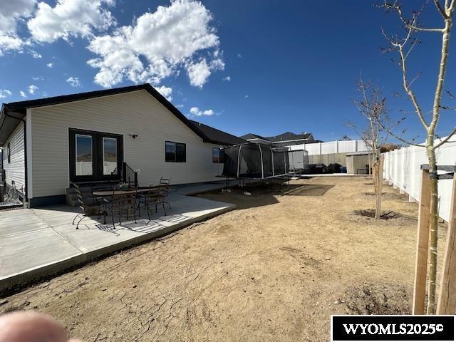 109 Chardonnay, Rock Springs, WY 82901 - rear view of property with a fenced backyard, a trampoline, a patio area, and french doors